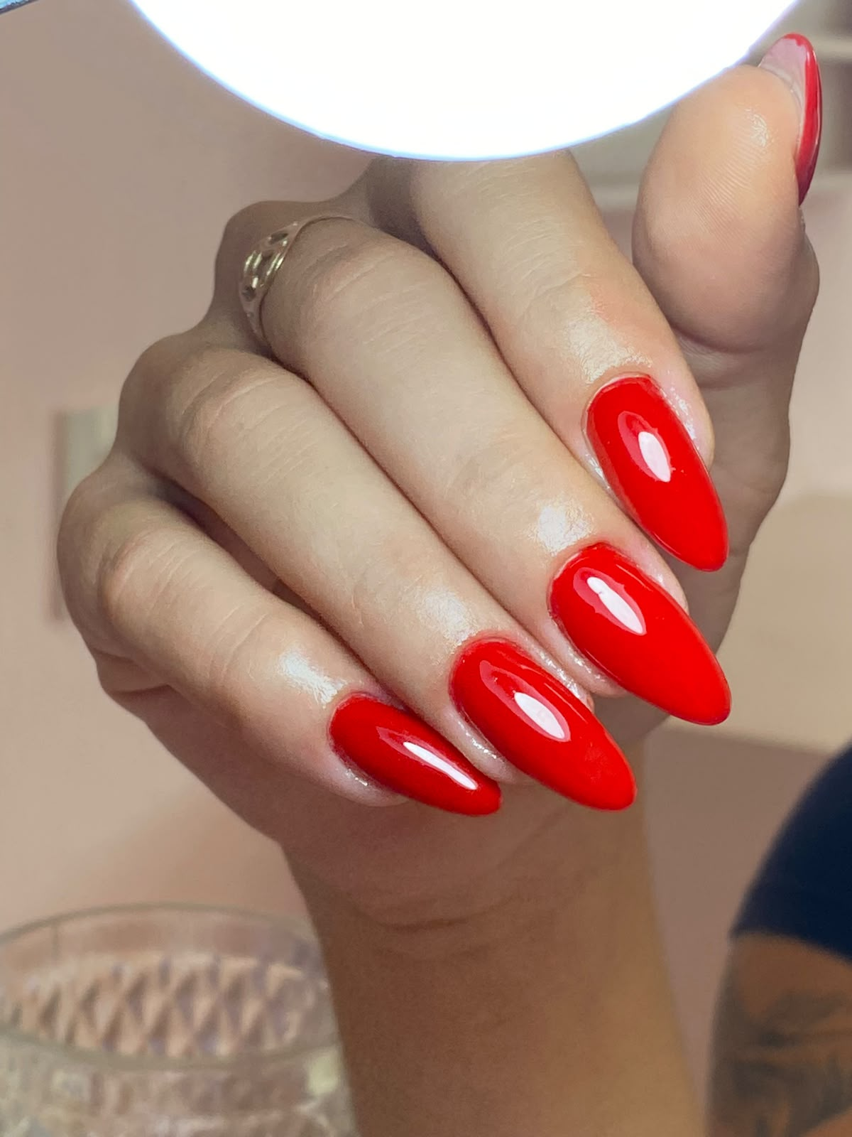 Esmaltação em gel vermelha em unhas amendoadas